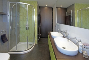 Barevnost koupelno-vého nábytku je sladěna s odstínem mozaiky. Prostor tak působí uceleným dojmem.