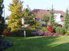 Jednotlivé zahradní části jsou komponovány s ohledem na barevný efekt dle ročních období. Záběr na kout s podzimními efekty. Nastupující babí léto se v zahradě prezentuje kvetoucími vřesy a zahradními hvězdnicemi. Barevnou harmonii doplňují barvící se dřeviny ambroň, brslen a perovskie.
