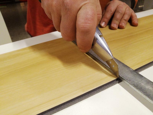 4) Pomocí úhelníku nebo kovového pravítka rovným nožem nařízněte nášlapnou vrstvu.