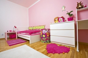Pokoj příjemně zateplují bavlněné koberečky, jak jinak než v růžové barvě