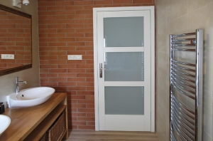 V horní koupelně je cihlový obklad použit u vstupu okolo dveří