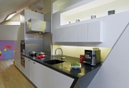 Kuchyň je přizpůsobena dynamice prostoru, boční strana je zkosená jako stropy v celém bytě