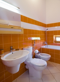 Sanitární keramiku a obklad tuzemské výroby majitel pořídil za přijatelnou cenu. Koupelna v oranžovo-bílém provedení vyznívá působivě a velmi elegantně.