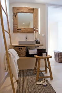 Koupelnu zdobí jemně krémový keramický obklad (Apavisa). Kromě sprchového koutu je vybavena jednoduchým cementovým umyvadlem, policemi a dalšími doplňky z masivního dřeva.