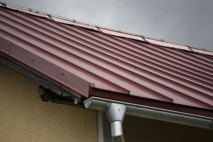 Špatný příklad kombinace kvalitní krytiny s levným plechem na hřebeni střechy. Životnost střechy se takovým krokem snižuje