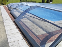 Výplň střechy ze silného polykarbonátu v konstrukci z práškově lakovaného hliníku je opatřena ochranou proti UV záření. Má speciální upevnění: chemické nerezové kotvy, do kterých se uchycují plasto-kovová fixační kolečka (DESJOYAUX).