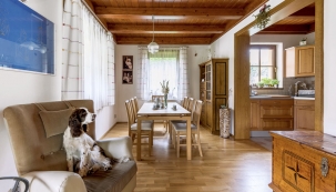 Obývací pokoj volně navazuje na jídelnu s kuchyní, jež jsou oproti němu laděné do dřeva.