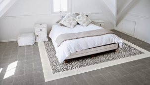 Španělský výrobce keramických dlažeb Ragno nabízí kolekci ve stylu retro (včetně formátu 20 × 20 cm), kterou lze uplatnit v celém domě. Například v ložnici nápaditě napodobí vzorovaný koberec na šedém neutrálním podkladu. Ideálně se hodí pro podlahové vytápění.