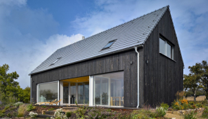 Vnější obklad fasády domu je z neupraveného severského modřínu s vertikální orientací, výrazné je i velkoformátové prosklení