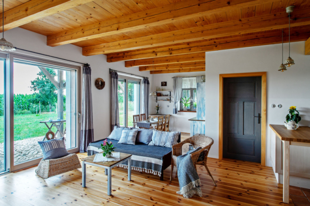 Společný obývací prostor. Strop a palubková podlaha jsou dílem Zorky a Stanislava a jsou sladěny s dveřními zárubněmi. Přírodní dřevo citlivě doplňují textilie v namodralých tónech