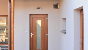 Vpravo nad vchodovými dveřmi je patrný průduch, který přivádí do domu čerstvý vzduch. Druhým průduchem v jiné části domu je naopak odváděn odpadní vzduch (zdroj: Schiedel)