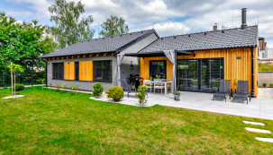 Dům o velikosti 110,4 m2 užitné plochy o dispozici 3 + kk má zajímavě kombinovanou fasádu z šedé omítky a dřevěného obkladu ze sibiřského modřínu