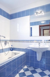 PRO KOUPELNU zvolili majitelé obkládačky bílé a modré. Pocit svěžesti, které tyto barvy vyvolávají, lehce podtrhuje pruh ze žlutě dekorovaných listel. Hluboká vana je vybavena podomítkovou baterií