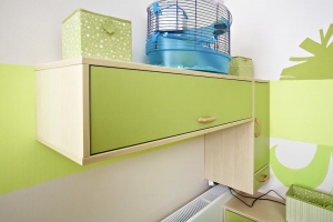 Pracovn&iacute; kout navazuje na linii n&aacute;bytku od postele. Design&eacute;rka zvolila možnost mobiln&iacute;ho posunov&aacute;n&iacute; stolu. Jakmile M&iacute;&scaron;u omrz&iacute; pohled do stěny, může stůl posunout k oknu s v&yacute;hledem do zahrady