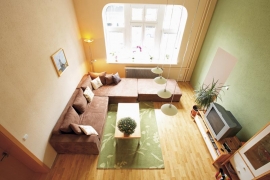 Designérka Lucie do obývacího pokoje zvolila závěsné osvětlení se čtyřmi lampami (MASSIVE). Bílé a zelenkavé mléčné sklo skvěle ladí s koncepcí celého prostoru