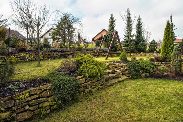 Majitelé spolu se zahradním architektem pečlivě vybírali, jaký rostlinný materiál se bude nejlépe hodit k cihlové fasádě. Proto v zahradě převažují jehličnany.