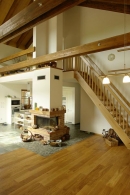 Nad kuchyňským koutem vznikla příjemná galerie, přístupná po dubovém schodišti, Trámoví nad obývací částí je nejvýraznějším architektonickým prvkem stavby. Lepené hranoly působí dojmem pravého masivu a těžko věřit, že tu jsou teprve rok, a ne několik desetiletí či století