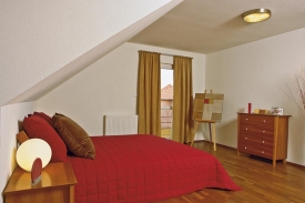 Z ložnice rodičů a koupelny se vchází na balkon umístěný ve štítu a částečně chráněný přesahující střechou
