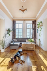Průchozí obývací pokoj s francouzskými okny umožňuje vstup na balkon, je tu i krb. Místnost slouží především k odpočinku a sledování televize.
