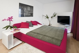 Ložnice se nese v purpurových odstínech. Postel Snowdonia (Ligne Roset), cena cca 63 000 Kč