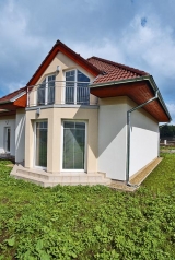 Dům se obrací do zahrady výrazným arkýřem s francouzskými okny a balkonem v patře