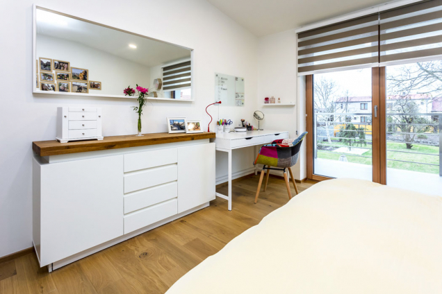 Z pokoje v podkroví se proskleným vstupem dostanete na prostorný balkon chráněný před sluncem přesahem střechy.