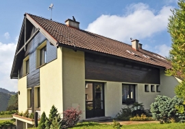 Hlavní štít je obrácen k východu a oživen geometricky komponovaným dřevěným obložením