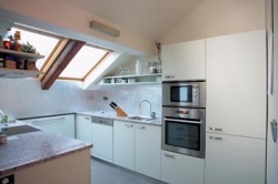 Kuchyň navrhl architekt. K bílému provedení zvolil kovové doplňky, se kterými koresponduje zvolená podlahová krytina