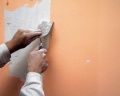 Obnovit fasádu vám může pomoci tenkovrstvá omítka. Nejprve oškrábejte starou barvu