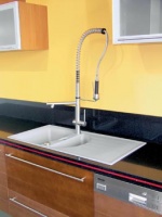 Pracovní deska je z lepeného třívrstvého umělého kamene Technistonu, typ Gobi Black - Starlight Ruby, dřez je osazený designovou baterií Gessi za 17 500 Kč (bez DPH)