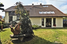 Téměř jednolitou sedlovou střechu s betonovými taškami narušují jen střešní okna, která do ateliéru přivádějí žádané severní světlo