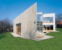 Betonová stěna oddělující dům od okolní zástavby měla být původně ještě o něco vyšší. Investoři však nechtěli přijít o výhled z terasy a navrhované "střílny proti barokním nájezdníkům" jim připadaly nedostatečné