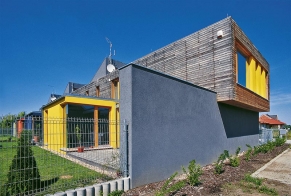 Dominantní část kompozice „čtyřdomu” tvoří dlouhý horizontální kvádr obložený modřínovým dřevem (druhé podlaží), který spočívá na omítnutém soklu (přízemí)