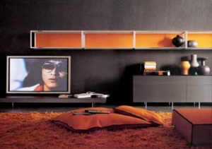 Nábytek z programu Pass (design Luca Meda, Molteni & C.). Nízký stolek pod TV v provedení wengé, podnož je hiníková (190 x 64 x 16 cm). Závěsný modul je kombinací eloxovaného hliníku a pískovaného skla, záda jsou oranžově lakovaná (96 x 30 x 32 cm), dvojitá skříňka se zásuvkami je lakovaná v odstínu čokoládově hnědé, vrchní deska je skleněná, nožky hliníkové. Cena sestavy 186 300 Kč, CAST INTERIORS