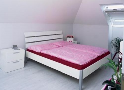Právě ložnice nejnápadněji prozrazuje majitelčinu náklonnost k růžové barvě