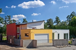 Z ulice má dům uzavřený civilní charakter, kompaktní severní stěnu architekt zvýraznil červeným nátěrem omítky