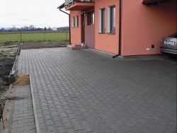 Vydlážděná plocha na severní straně před vchodem do domu