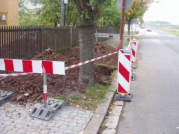 Rozkopaný chodník svědčí o tom, že se zde budují přípojky na vodovod a kanalizaci