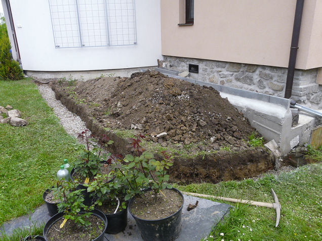 Svah u domu se srovnal opěrnou zídkou, za kterou vznikl rovinatý záhon s pestrou výsadbou. Nová zídka kopíruje styl a materiál soklu starého zrekonstruovaného domu.