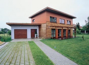Dům obdélníkového půdorysu je obložen modřínem a deskami Cetris a obrácen přímo k jihu. Jedním z mála betonových prvků jsou vkusné zatravňovací dlaždice u vjezdu do garáže