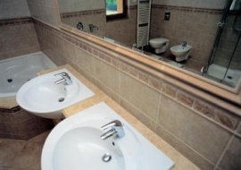 Prostorná hlavní koupelna je vybavena rohovou hydromasážní vanou Riho, sprchovým koutem, závěsným WC a bidetem, dvěma umyvadly s velkým zrcadlem, dvěma žebříčkovými radiátory, italskou keramickou dlažbou a saunovou kabinou