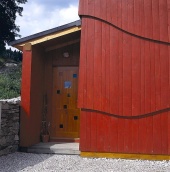 Detail hlavního vstupu. Vstupní chodba má stejný sklon střechy jako hlavní obytná část domu