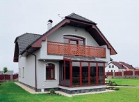 K západnímu štítu je přistavěna zimní zahrada. Dřevěné rámy jsou, stejně jako u balkonu a podbití střechy, mořeny