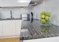 Kuchyň zdobí prvky z matné nerezové oceli, ve stejném designu je i pracovní deska linky
