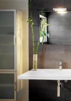Rodinnou koupelnu v patře charakterizují obkládačky lpuri 30 x 60 cm v antracitové a pískové barvě. Dvojité umyvadlo je od firmy Laufen, baterie vyrobil Ideal Standard a Hansgrohe