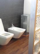 WC s bidetem oddělují od koupelny posuvné skleněné dveře, od chodby zase stěna z luxferů