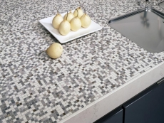 Pracovní deska (SieMatic), mozaika sklo, barevné kovy, keramiky (1 x 1 cm), ruční práce, přední hrana Bianco Perlino, tloušťka 8 cm. Cena (bez DPH) 133 000 Kč/bm, STOPKA