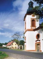 Domeček za kostelíkem. Odtud vypadá jako milé, ale skoro obyčejné stavení. Jenže zdání, jak jsme viděli - klame...