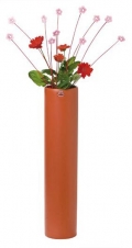 Hrnková gerbera umístěná do vysoké vázy s přírodním ozdobením - loupané proutky zakončené dřevěnými kvítky