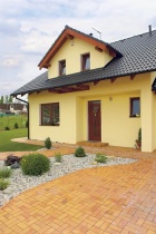 Elegantní pálená dlažba Klinker vás z východní strany dovede až do závětří vstupních dveří. Střeše dominují Římské tašky Bramac a mohutný vikýř